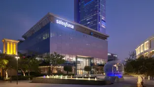 Image of Dubai saleforce office at night, glass windows that reflects the purple ambiance of the night sky.