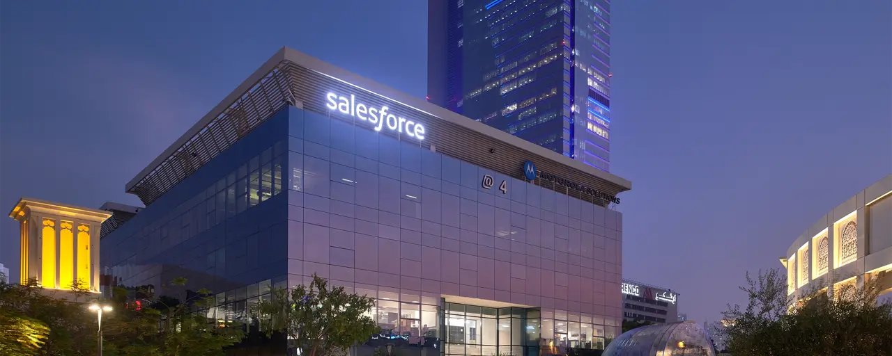 Image of Dubai saleforce office at night, glass windows that reflects the purple ambiance of the night sky.