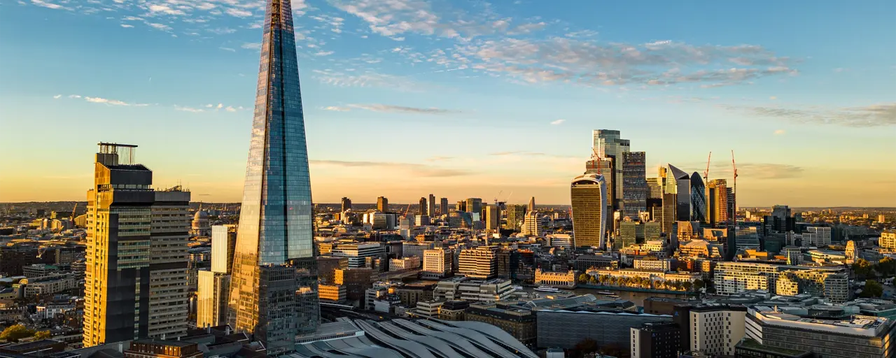 Skyline view of London buildings during sunrise, featuring the shard.