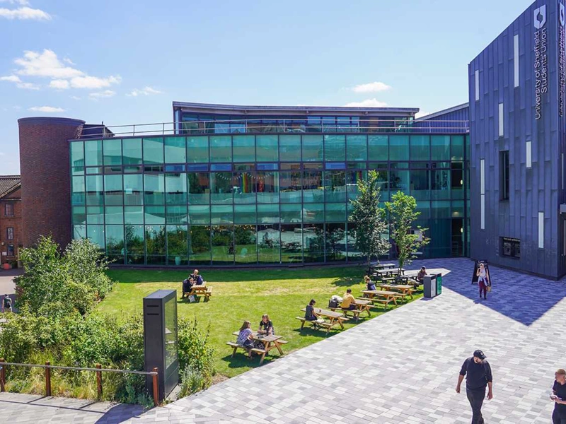 University of Sheffield’s student union, a modern building with students roaming the courtyard in front