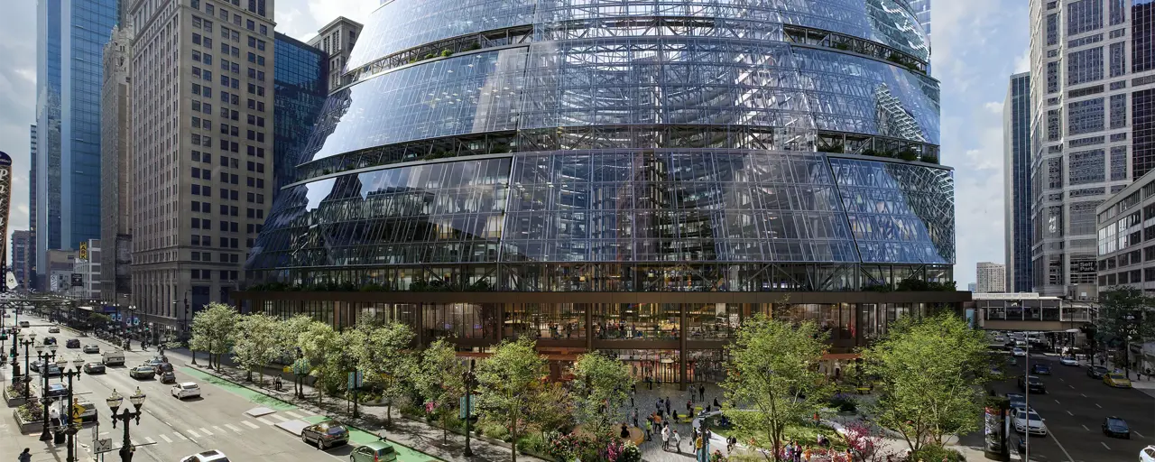 The Google Thompson Center in Chicago, a 17-storey, glass fronted building set to a backdrop of cars and greenery. 