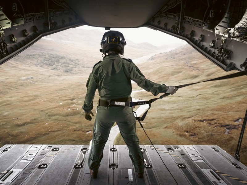 An RAF Atlas C.1 A400M Load Master looks out to the Cairngorm mountains whilst ramp riding during a low level training sortie through the Scottish Highlands.