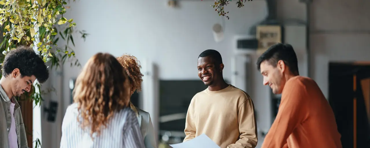 Diverse group of young people working in an office space with plants