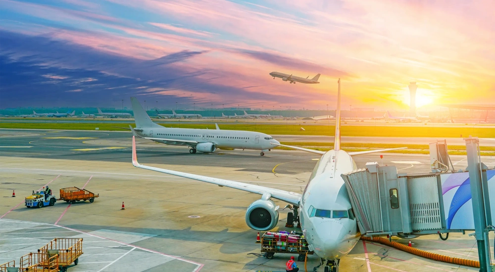 Flights management air control tower and passenger terminal in international airport with flying climb plane jet, taxiing, ready for departure gangway in clouds sky sunset dawn.