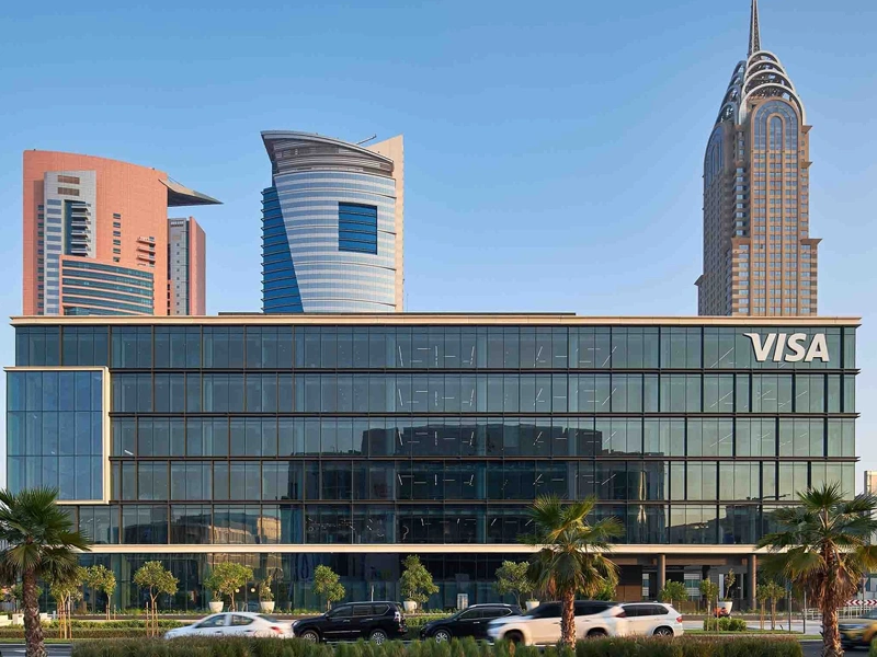 VISA headquarters with glass exterior facade and skyscrapers in the background, Dubai, UAE