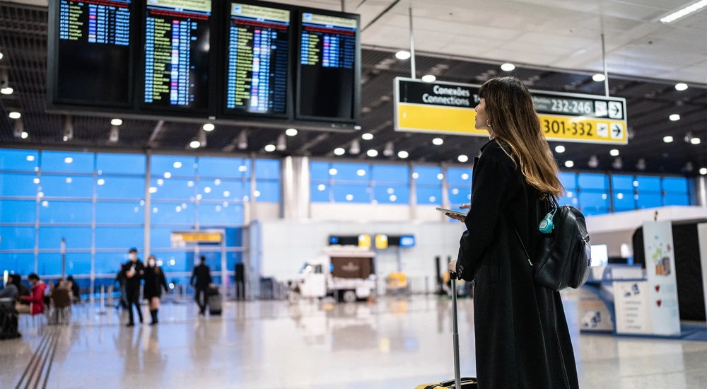 Portrait of a young woman using the mobile phone in the airport