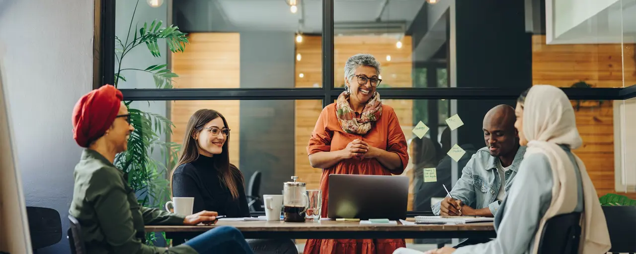 Five professionals sitting around a work desk in a office