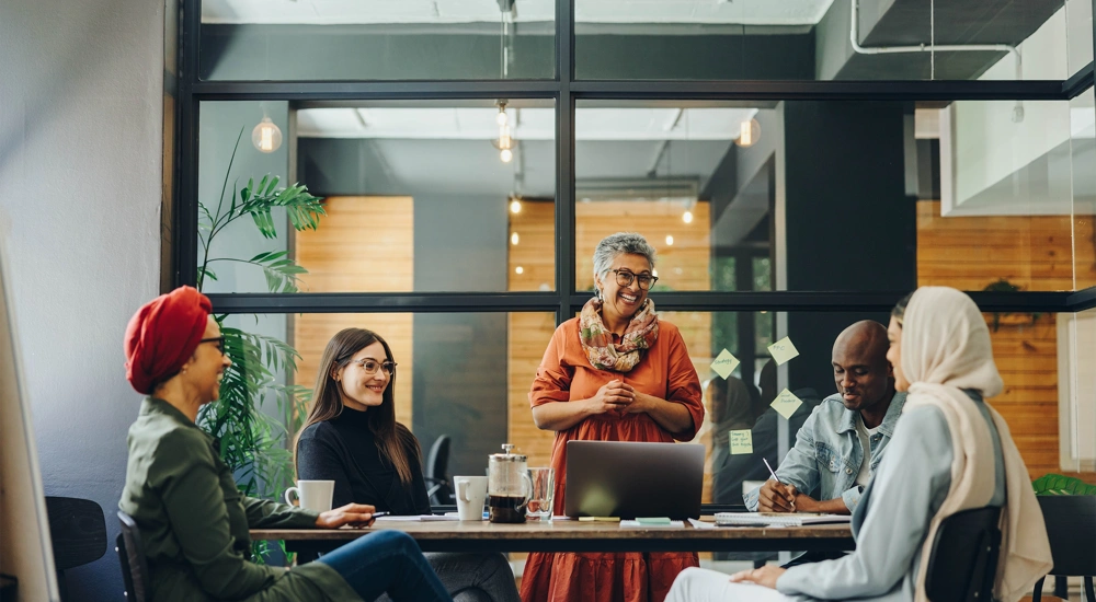 Five professionals sitting around a work desk in a office