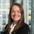 Portrait of Georgina Bishop, Associate Director, Cost Management, with city landscape featuring building with lots of windows in the background.