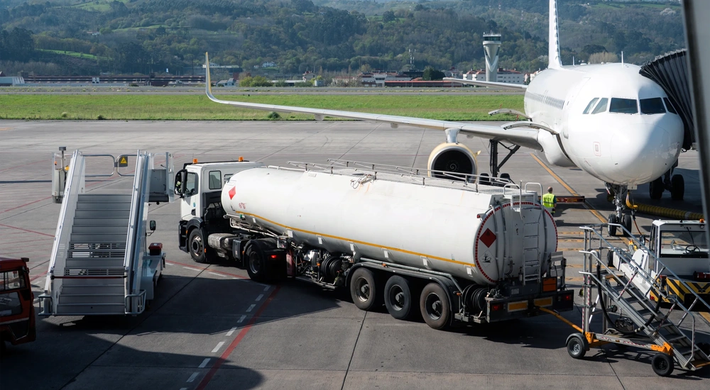 Fuel tanker truck refueling aircraft on airport apron. Concept of aviation fuel logistics, transportation infrastructure and airport operations.